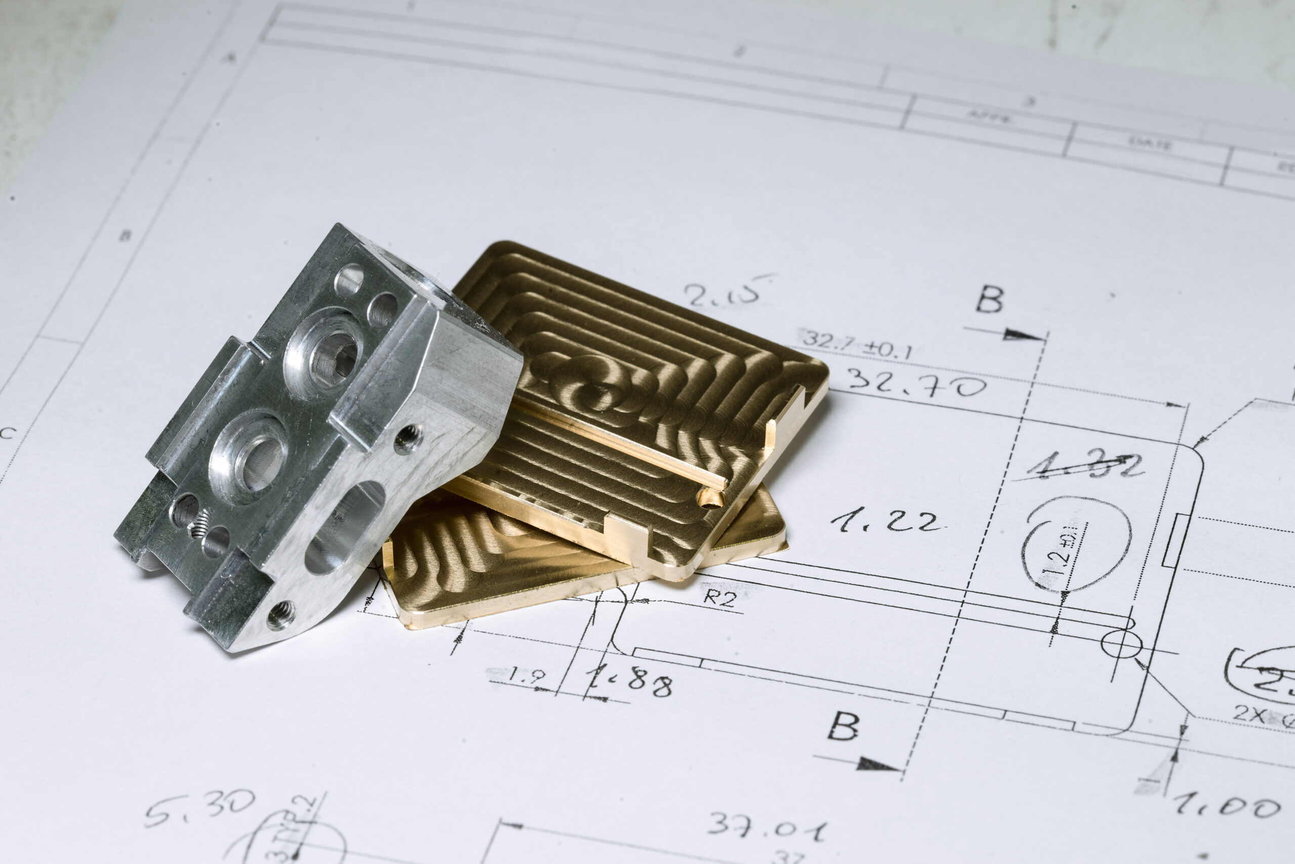 Ready CNC golden and silver metal detail on technical drawing sketch with measures